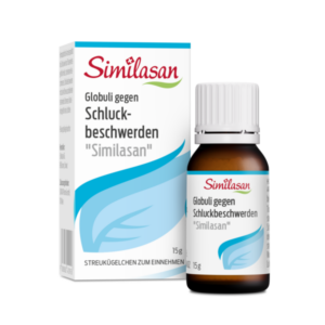 Eine Flasche mit Globuli gegen Schluckbeschwerden "Similasan" neben der Verpackung, auf der die Anwendungshinweise stehen.