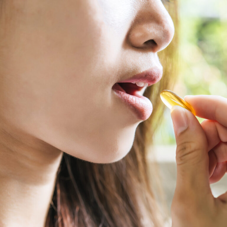 Young woman taking medicine pill after doctor order