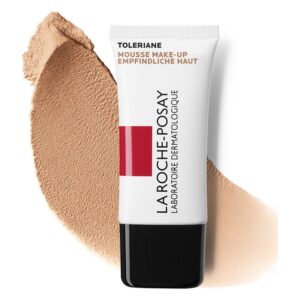 Toleriane Mousse Make-up von La Roche-Posay in einer weißen Tube mit schwarzem Verschluss und beiger Farbnuance daneben.