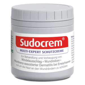 Runde, graue Dose mit Sudocrem Schutzcreme und rotem Schriftzug, behandelt Hautprobleme.